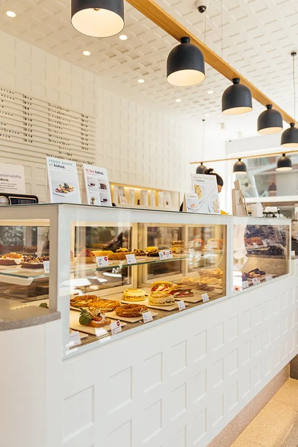 The white-tiled café counter with pastries, seen through the display.