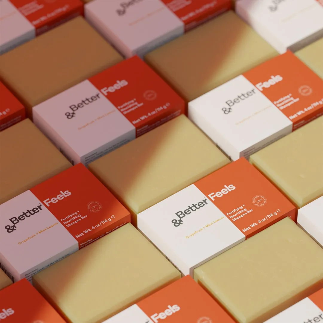 Rows of '&Better Feels' boxes and cream soap bars laid out in a diagonal pattern.