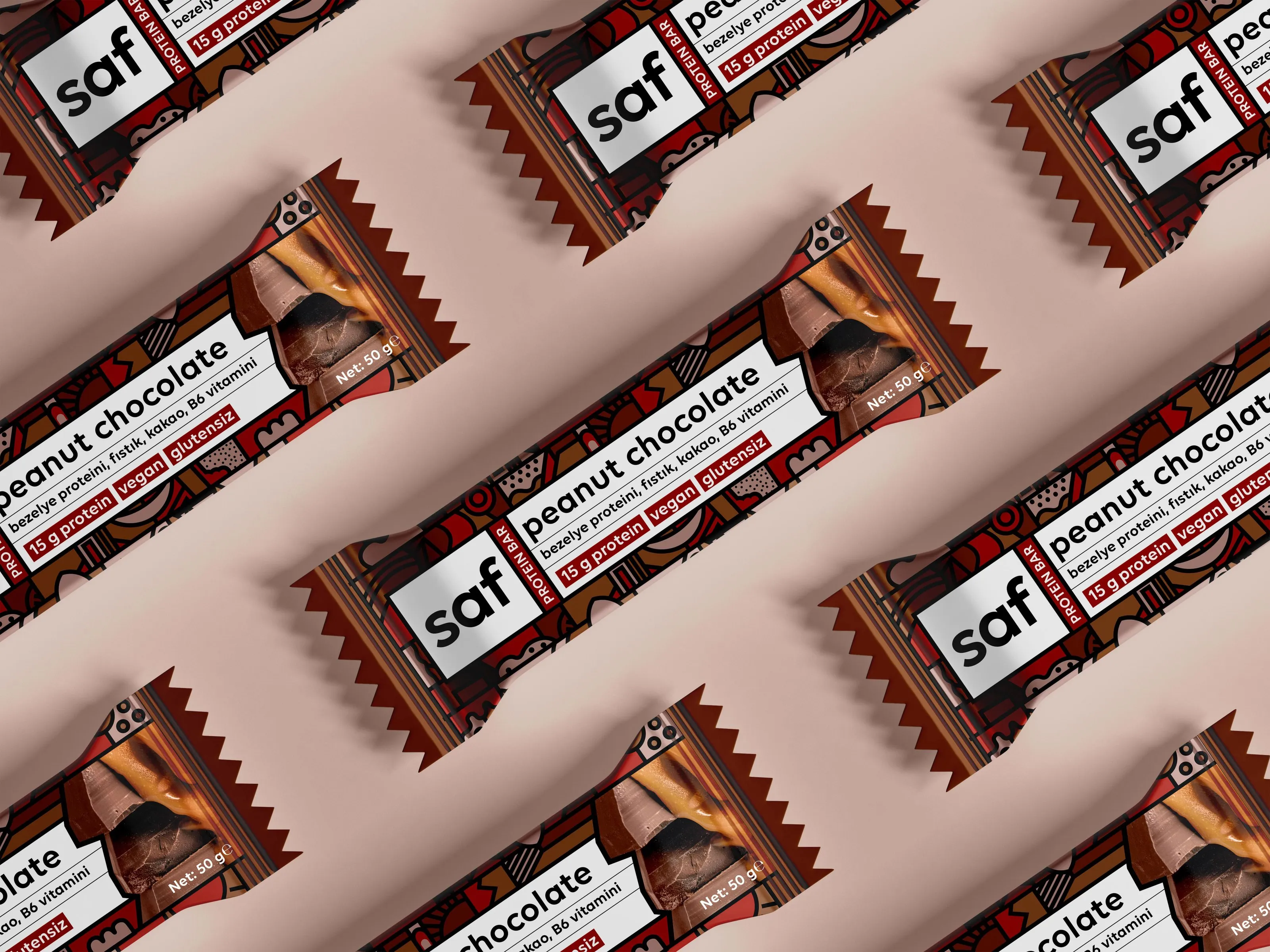 Saf peanut chocolate bars laid diagonally on a dusty pink background.