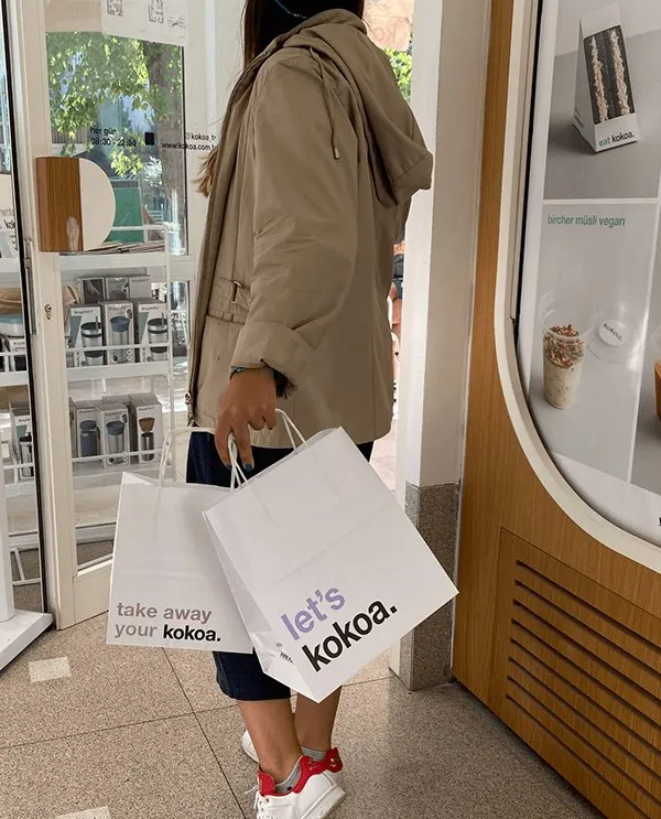 Paper bags printed 'take away your kokoa.' and 'let's kokoa.' carried out of the café.